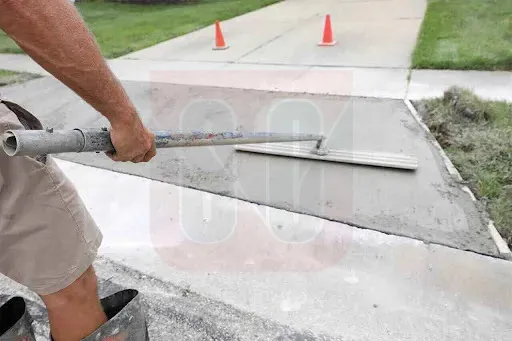 A man using a concrete pump to pour concrete for driveway repairs and replacement