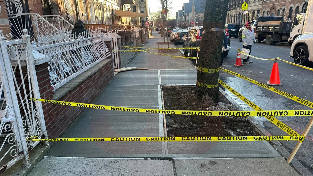 A sidewalk cordoned off with yellow and caution tape, indicating a restricted area for safety reasons